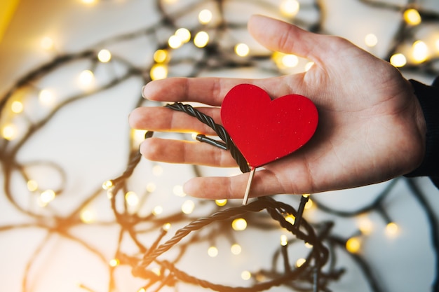 girl holding a red heart in the hands