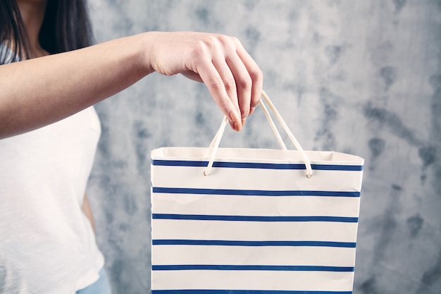 Ragazza che tiene una borsa della spesa.