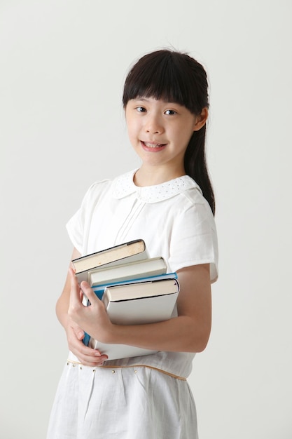 Girl holding stack of books