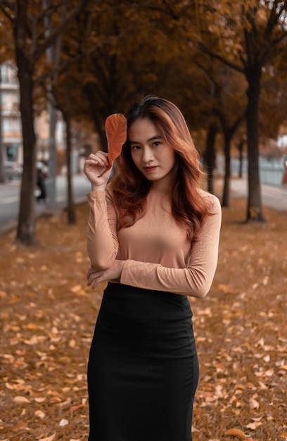 girl holding tree leaves in autumn scene