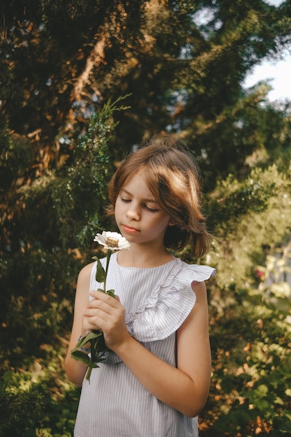 girl holding white daisy