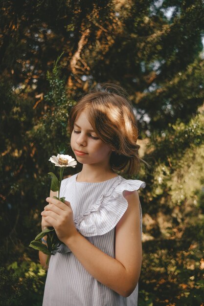 girl holding white daisy