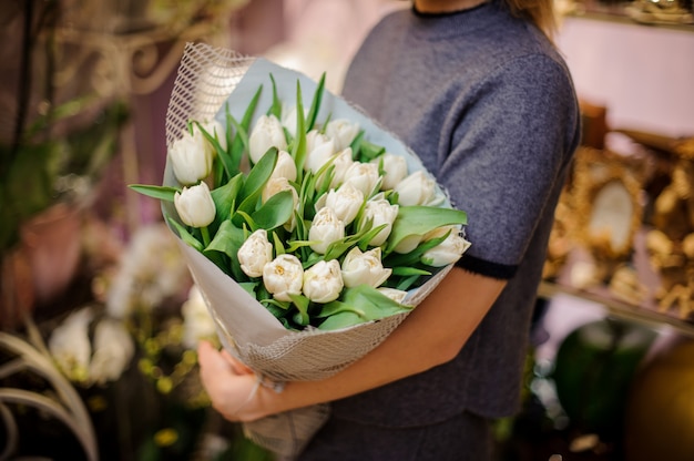 Girl holding a wonderful bouquet of white tulips