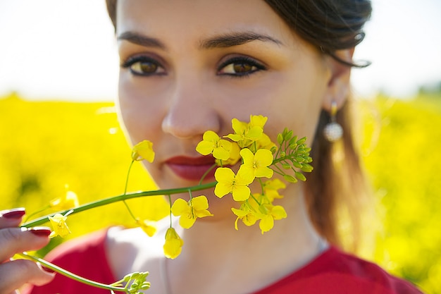 Foto ragazza che tiene fiore giallo vicino al fronte, primo piano