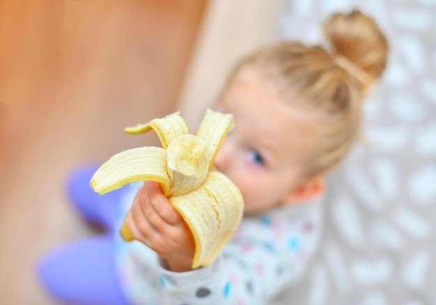 Girl holds a banana in her hands