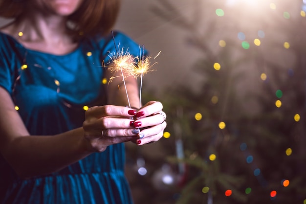 Foto la ragazza tiene le luci del bengala - buon natale e buone feste