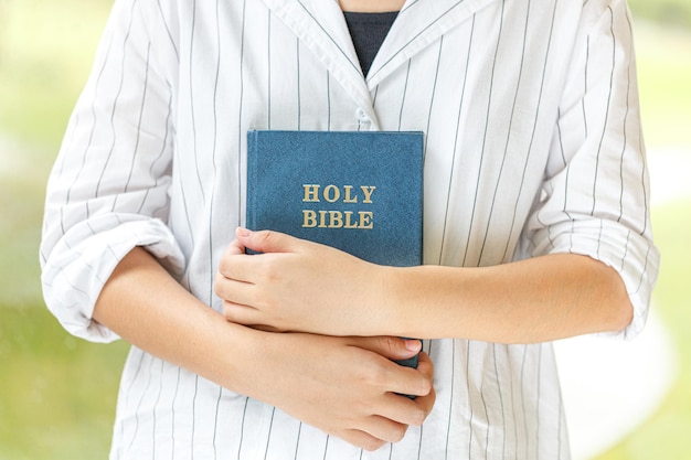 Girl holds bible in her hands Concept for faith religion spirituality hope and peace