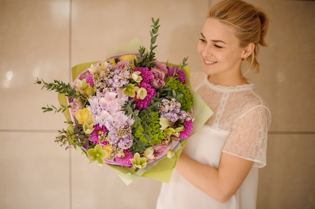 Girl holds big bouquet of different flowers