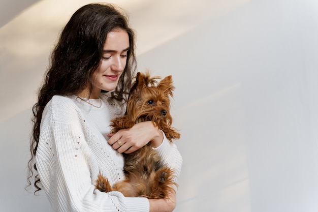 Girl holds brown dog isolated on white wall