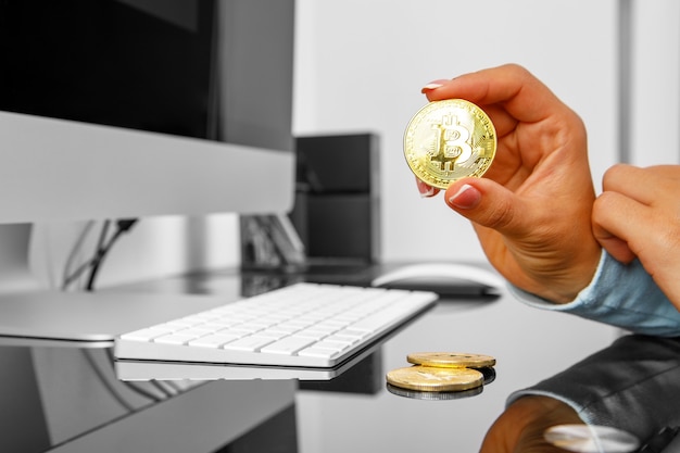 Girl holds a crypt in bitcoin his hand on a laptop background