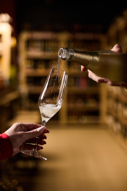 The girl holds a glass in which champagne is poured