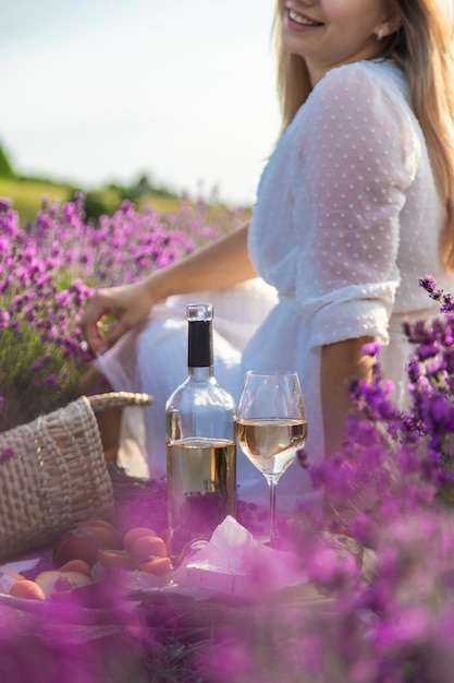 The girl holds a glass of wine on the background of a lavender field Selective focus