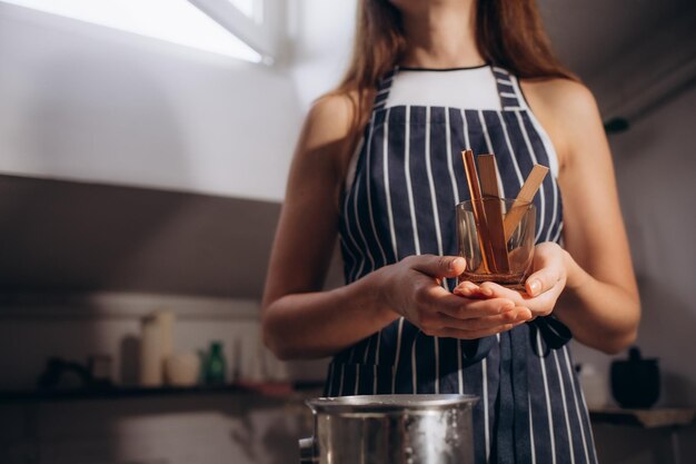 The girl holds a glass with a wooden wick