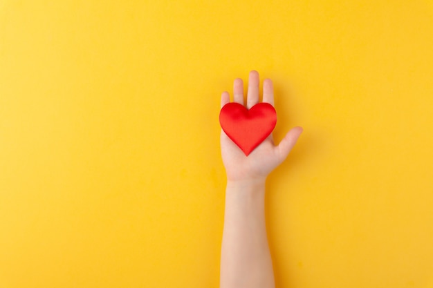 Girl holds in hands red hearts, children arms, love and valentines day concept