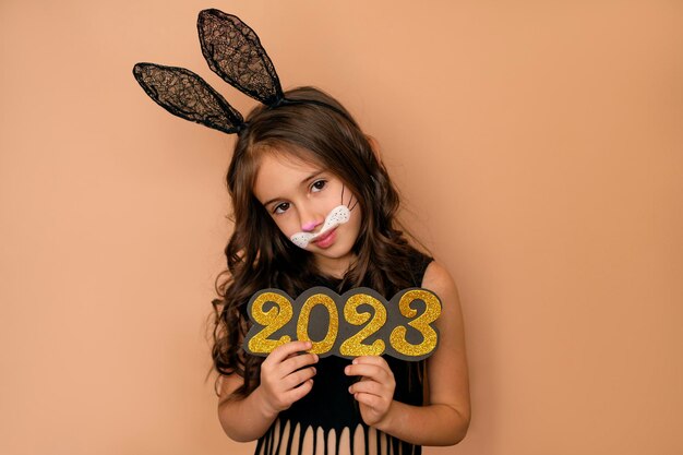 The girl holds in her hands the golden numbers of the new year 2023