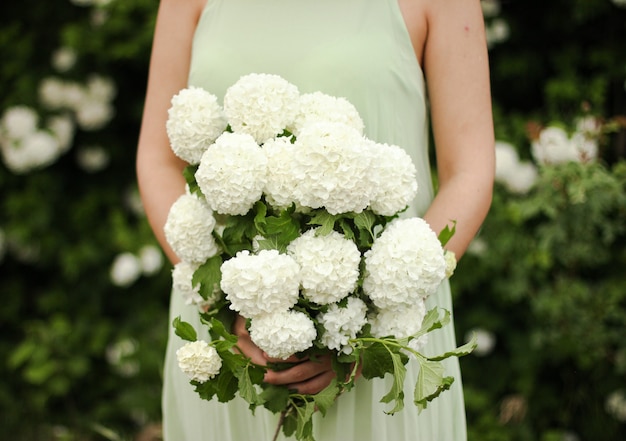 Girl holds in her hands a large bouquet of white flowers