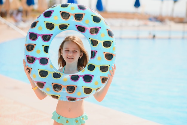 Girl holds an inflatable circle for swimming by the pool