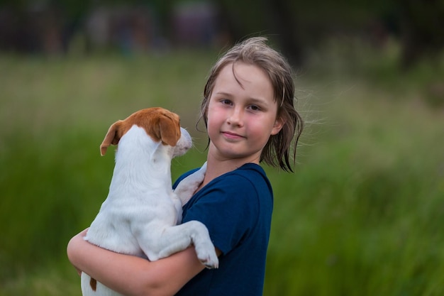 Girl holds Jack Russell terrier soft focus