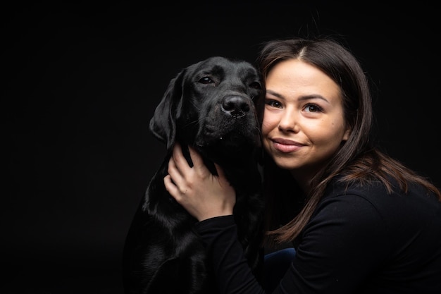 A girl holds a Labrador Retriever dog in her arms