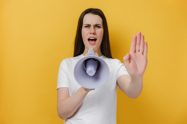 girl holds megaphone with open hand doing stop