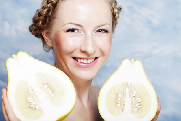 Girl holds in really big citrus fruit pamelo