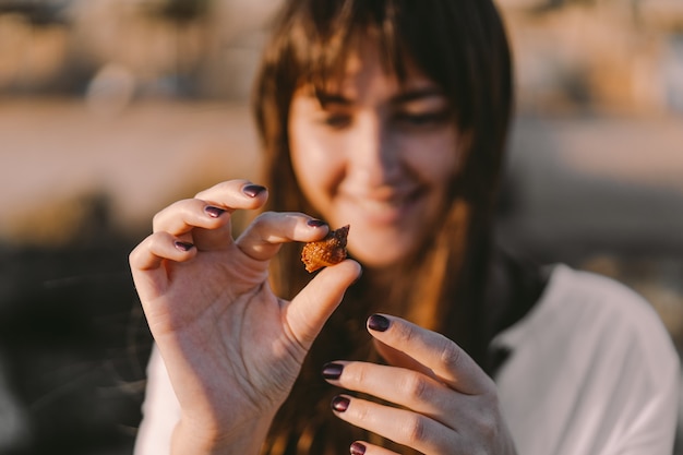 The girl holds a sea inhabitant in a shell on her hand