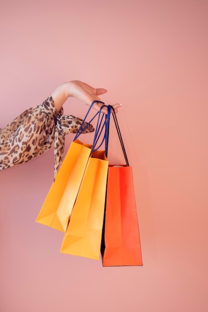 a girl holds shopping bags on a colored background