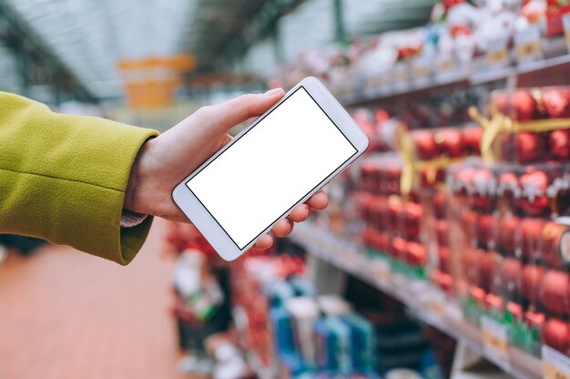 The girl holds a smartphone mockup in her hands.