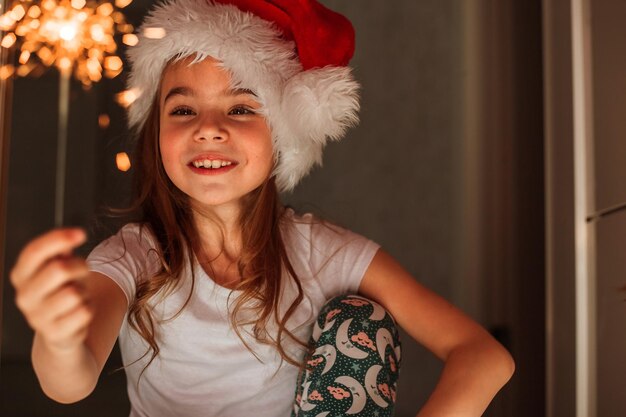 Una ragazza tiene le stelle filanti nel cappello di babbo natale il miracolo di natale