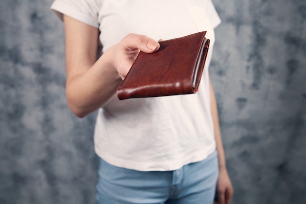 Фото Девушка держит в руках кошелек и берет деньги