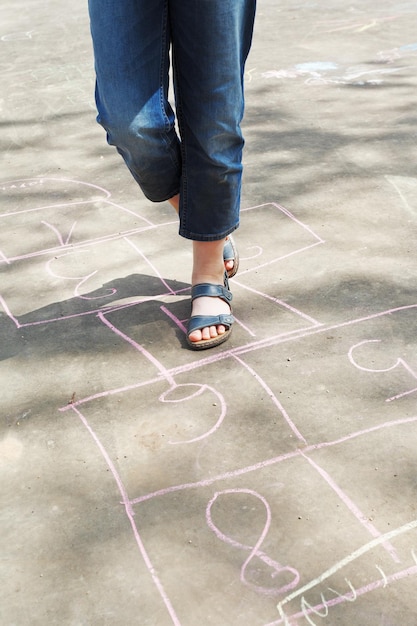 Girl hoping in hopscotch outdoors