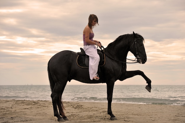 Girl and  horse on the beach