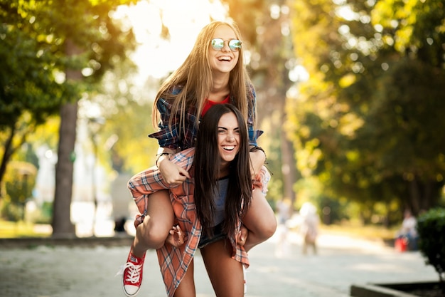 Ragazza a cavallo sulla schiena della sua amica