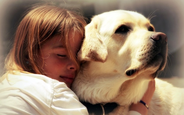 Foto una ragazza che abbraccia un cane con una ragazza e un cane