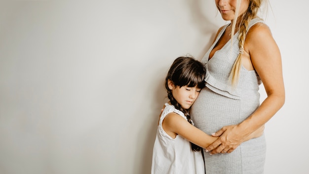 Ragazza che abbraccia la madre incinta