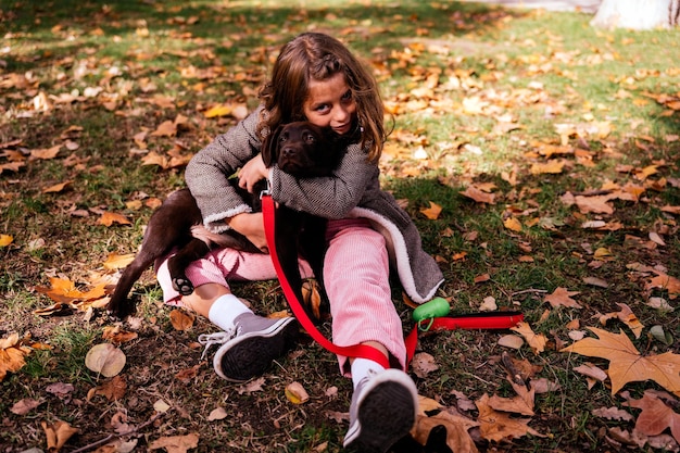 Girl hugging puppy on lawn