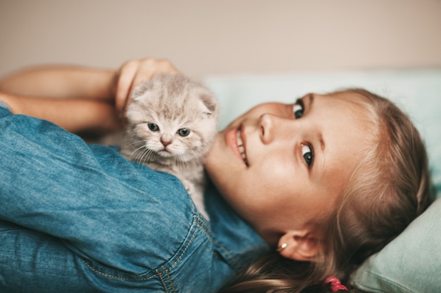 女の子はイギリスの小さな子猫を抱擁します。