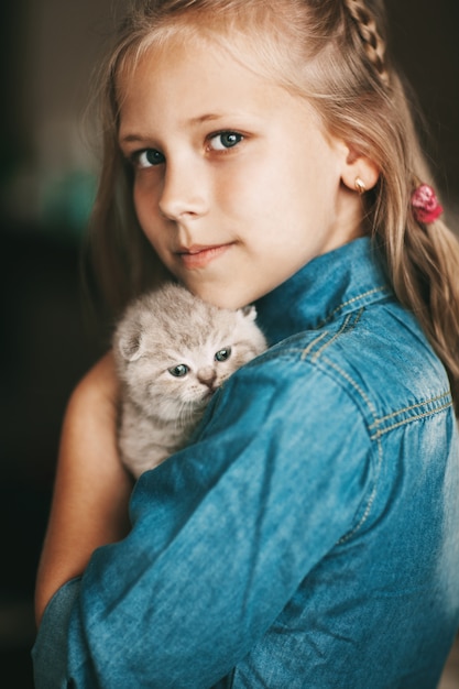 Girl hugs a british little kitten