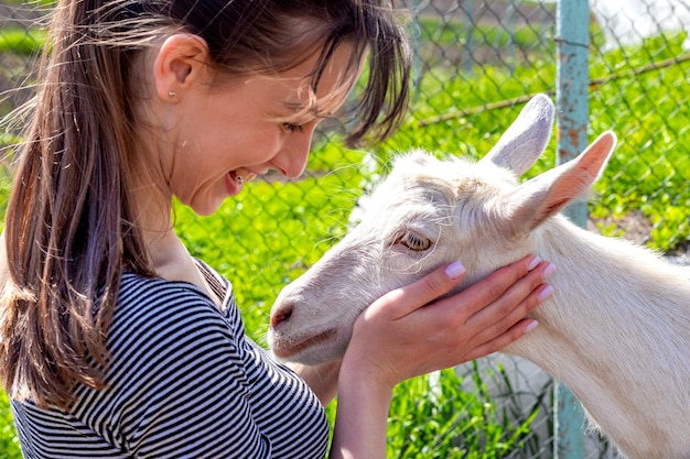 The girl hugs a goat. Love for animals