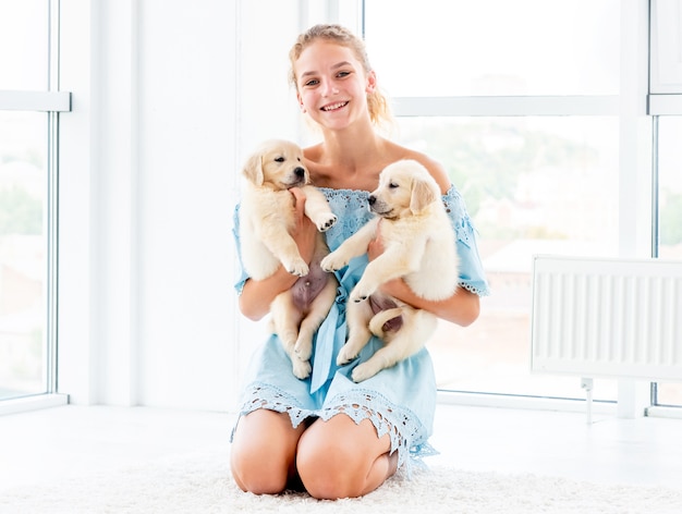 girl hugs retriever puppies