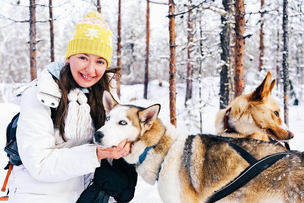 冬のラップランドのフィンランドのそりで女の子とハスキー犬。