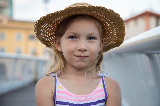 写真 帽子をかぶった女の子が街を歩いています