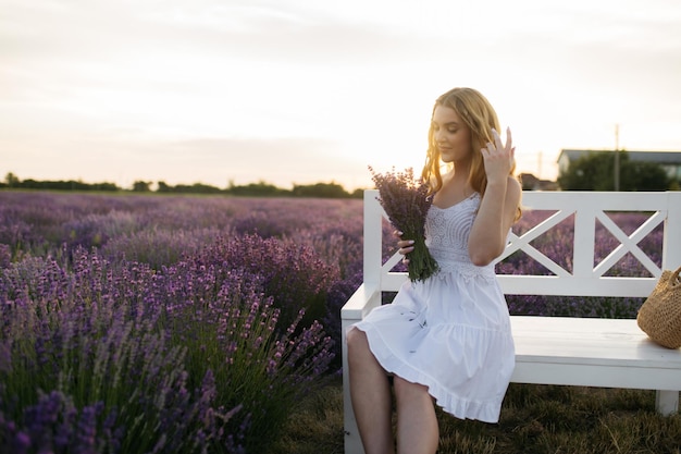 写真 ラベンダー畑の少女白いドレスを着た日没時のラベンダーの花畑の女フランスプロヴァンス