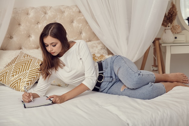 写真 ベッドに横になっているジーンズの女の子