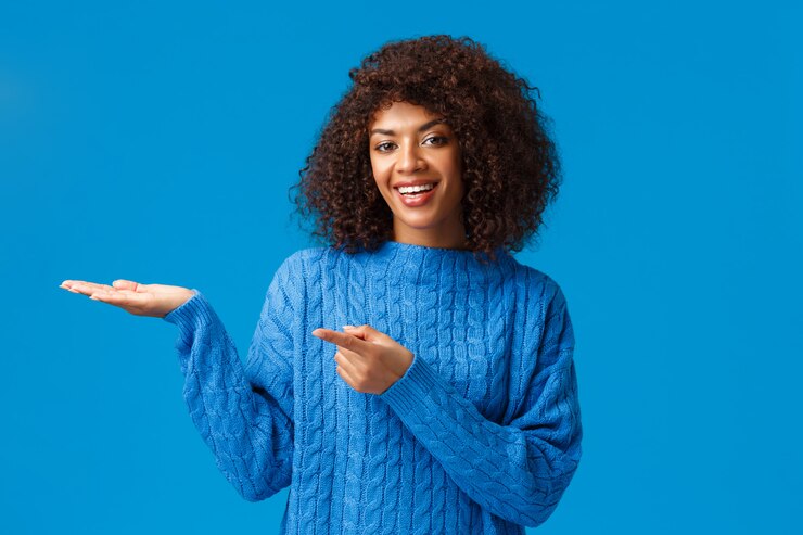 Photo girl introducing boyfriend to her family during winter holidays celebration, smiling joyful, pointing and holding palm left to show something, grinning delighted, recommend visit page, see discounts