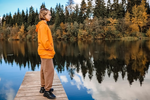 Girl is in the autumn park Autumn atmosphere scenic view of the river