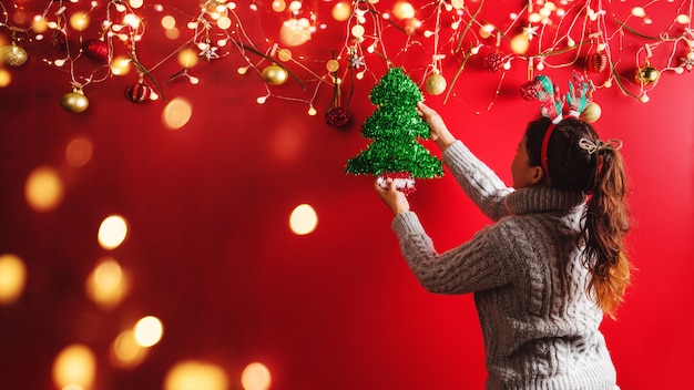 Foto la ragazza sta decorando con ornamenti natalizi