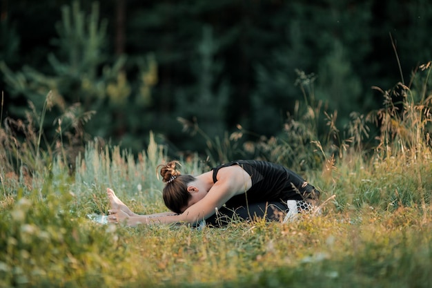 Foto la ragazza sta facendo yoga all'aria aperta il concetto di sport