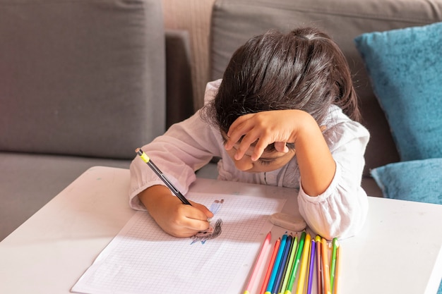 Girl is drawing and painting at a small table