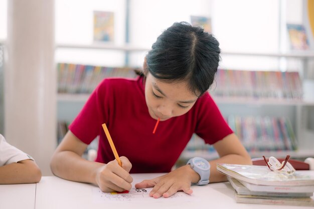 A girl is drawing on a piece of paper with a pencil